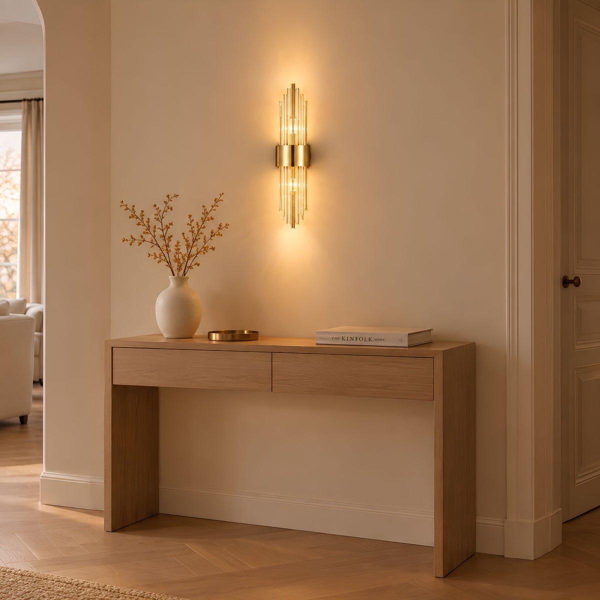 Applique murale dorée LYRA au-dessus d'une console en bois dans une entrée