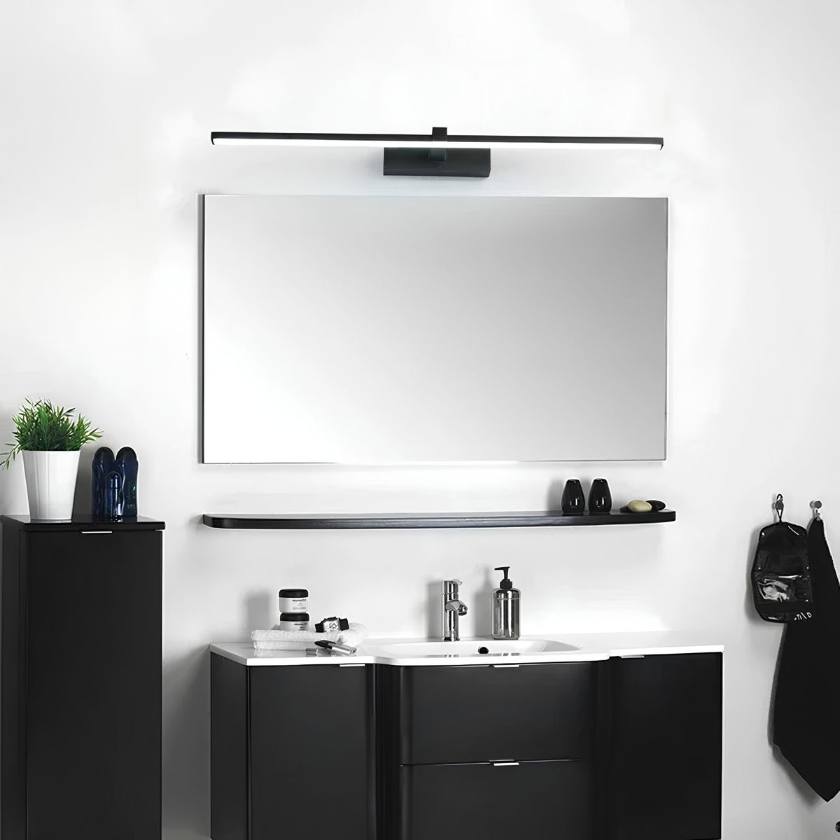 Applique murale LED LARA noire au-dessus d'un miroir et d'un meuble vasque