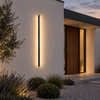 Applique murale extérieure LED IP65 VERA allumée sur une façade de maison au crépuscule