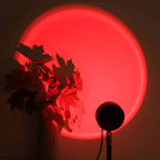 Lampe coucher de soleil SUNSET projetant une lumière rouge derrière une plante