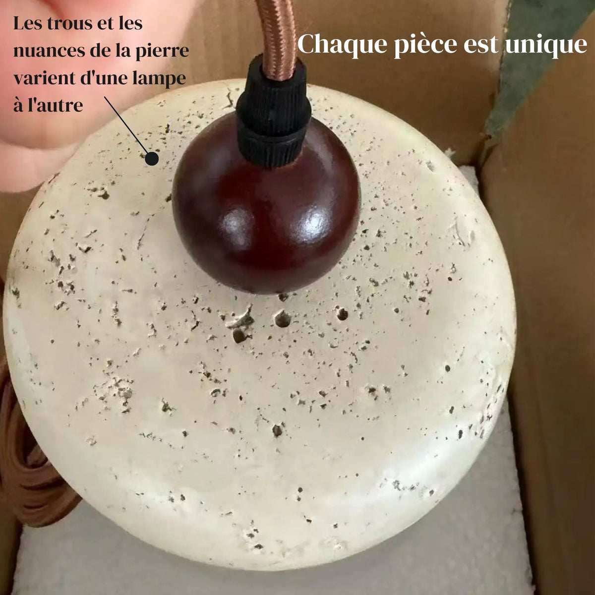 Gros plan sur la texture de la pierre et la sphère en bois de la suspension PETRA