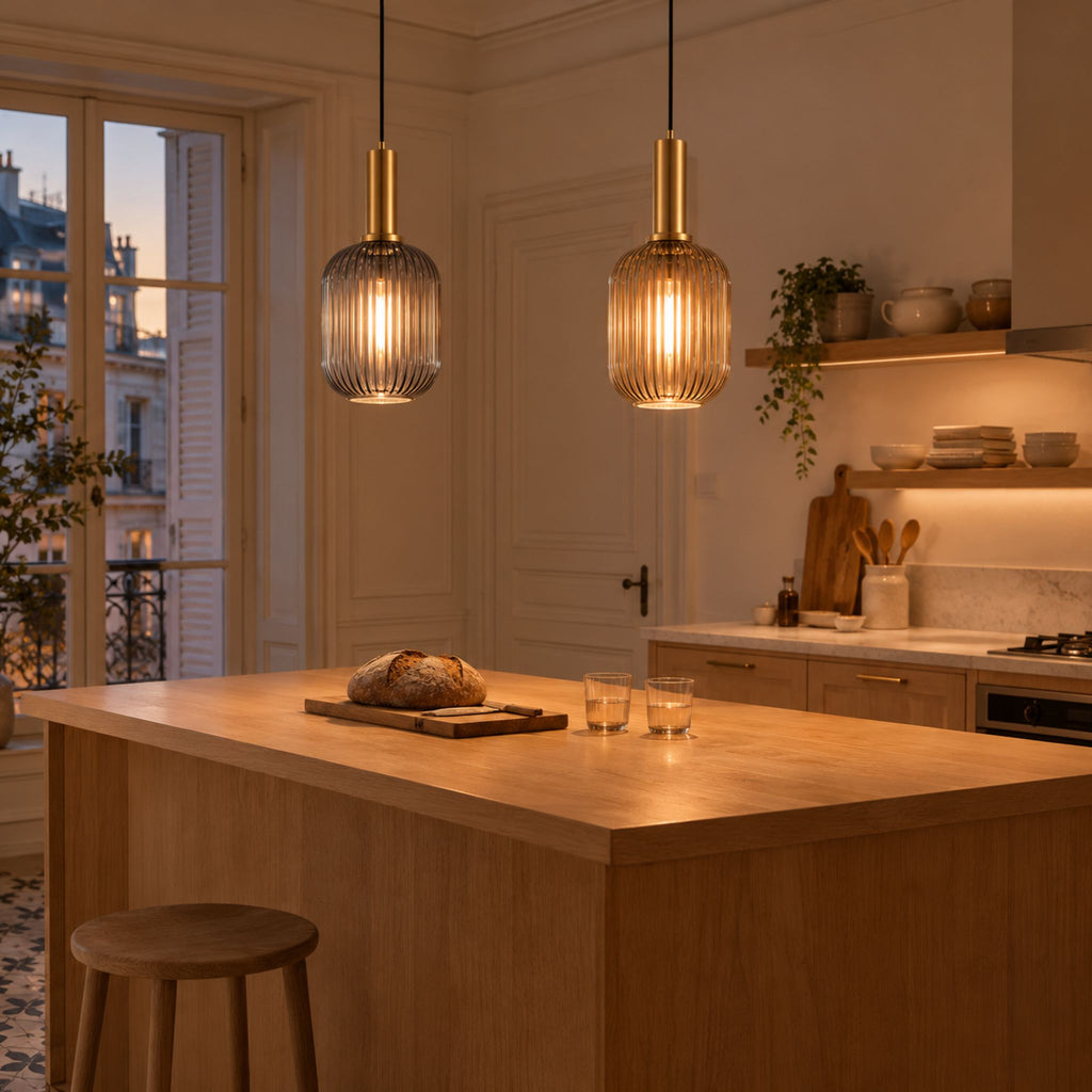 Deux suspensions ELIA en verre strié gris fumé et cognac allumées au-dessus d'un îlot de cuisine en bois